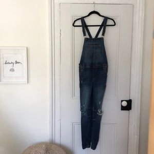 Skinny jean overalls with ripped knees